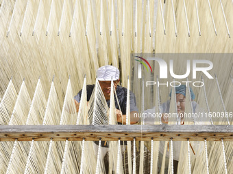 A worker processes hollow hanging noodles at a workshop in Suqian, Jiangsu province, China, on September 22, 2024. (