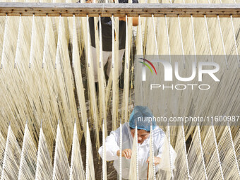 A worker processes hollow hanging noodles at a workshop in Suqian, Jiangsu province, China, on September 22, 2024. (