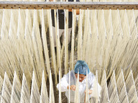 A worker processes hollow hanging noodles at a workshop in Suqian, Jiangsu province, China, on September 22, 2024. (