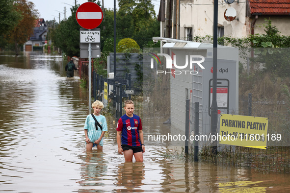 Children walk in the water after Nysa Klodzka river flooded town of Lewin Brzeski in southwestern Poland, on September 19th, 2024. Storm Bor...