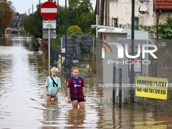 Children walk in the water after Nysa Klodzka river flooded town of Lewin Brzeski in southwestern Poland, on September 19th, 2024. Storm Bor...