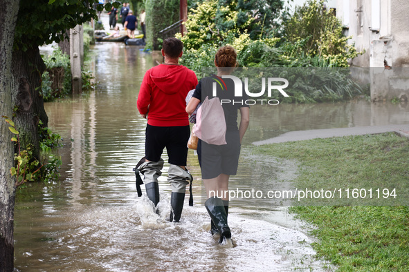 Residents walk in the water after Nysa Klodzka river flooded town of Lewin Brzeski in southwestern Poland, on September 19th, 2024. Storm Bo...