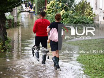 Residents walk in the water after Nysa Klodzka river flooded town of Lewin Brzeski in southwestern Poland, on September 19th, 2024. Storm Bo...