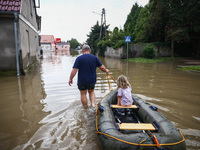 A man with a girl and a raft are seen in the water after Nysa Klodzka river flooded town of Lewin Brzeski in southwestern Poland, on Septemb...