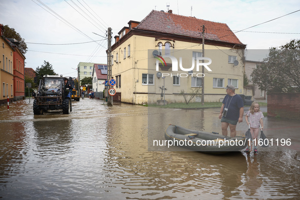 A man with a girl and a raft are seen in the water after Nysa Klodzka river flooded town of Lewin Brzeski in southwestern Poland, on Septemb...