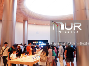 Customers experience Apple's new flagship mobile phone, the iPhone 16, at the largest Apple flagship store in Asia in Shanghai, China, on Se...