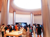 Customers experience Apple's new flagship mobile phone, the iPhone 16, at the largest Apple flagship store in Asia in Shanghai, China, on Se...