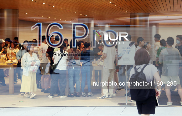 Customers experience Apple's new flagship mobile phone, the iPhone 16, at the largest Apple flagship store in Asia in Shanghai, China, on Se...