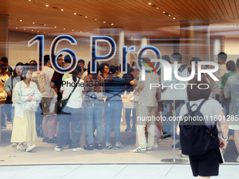 Customers experience Apple's new flagship mobile phone, the iPhone 16, at the largest Apple flagship store in Asia in Shanghai, China, on Se...