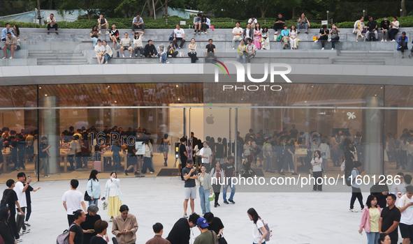 Customers experience Apple's new flagship mobile phone, the iPhone 16, at the largest Apple flagship store in Asia in Shanghai, China, on Se...