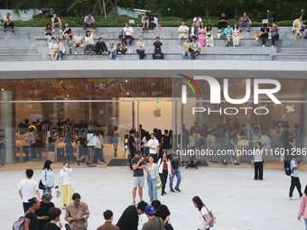 Customers experience Apple's new flagship mobile phone, the iPhone 16, at the largest Apple flagship store in Asia in Shanghai, China, on Se...