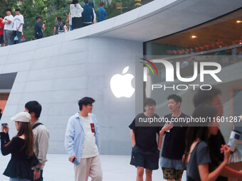 Customers experience Apple's new flagship mobile phone, the iPhone 16, at the largest Apple flagship store in Asia in Shanghai, China, on Se...