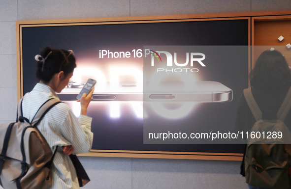 Customers experience Apple's new flagship mobile phone, the iPhone 16, at the largest Apple flagship store in Asia in Shanghai, China, on Se...