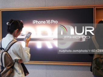 Customers experience Apple's new flagship mobile phone, the iPhone 16, at the largest Apple flagship store in Asia in Shanghai, China, on Se...