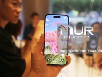 Customers experience Apple's new flagship mobile phone, the iPhone 16, at the largest Apple flagship store in Asia in Shanghai, China, on Se...