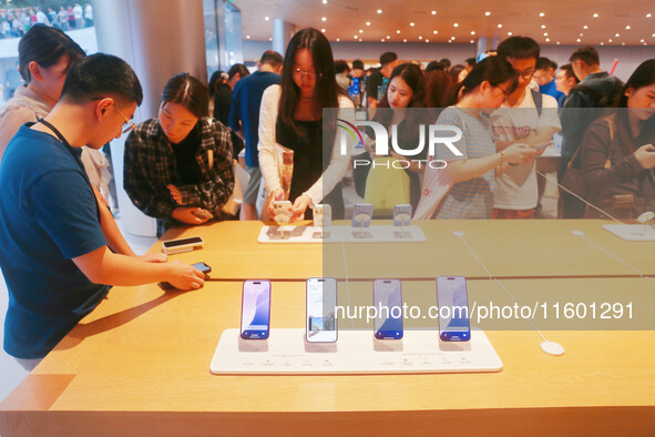 Customers experience Apple's new flagship mobile phone, the iPhone 16, at the largest Apple flagship store in Asia in Shanghai, China, on Se...