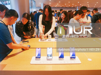 Customers experience Apple's new flagship mobile phone, the iPhone 16, at the largest Apple flagship store in Asia in Shanghai, China, on Se...