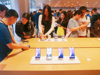 Customers experience Apple's new flagship mobile phone, the iPhone 16, at the largest Apple flagship store in Asia in Shanghai, China, on Se...