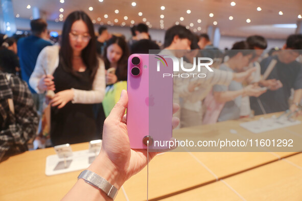 Customers experience Apple's new flagship mobile phone, the iPhone 16, at the largest Apple flagship store in Asia in Shanghai, China, on Se...