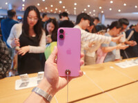 Customers experience Apple's new flagship mobile phone, the iPhone 16, at the largest Apple flagship store in Asia in Shanghai, China, on Se...