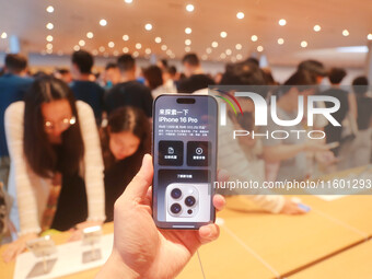 Customers experience Apple's new flagship mobile phone, the iPhone 16, at the largest Apple flagship store in Asia in Shanghai, China, on Se...