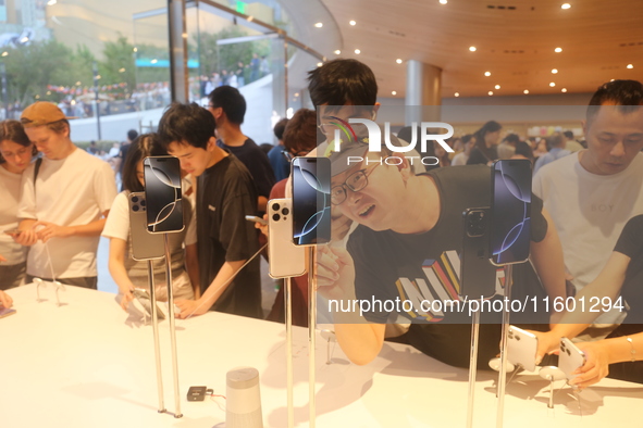 Customers experience Apple's new flagship mobile phone, the iPhone 16, at the largest Apple flagship store in Asia in Shanghai, China, on Se...