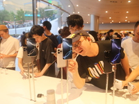 Customers experience Apple's new flagship mobile phone, the iPhone 16, at the largest Apple flagship store in Asia in Shanghai, China, on Se...