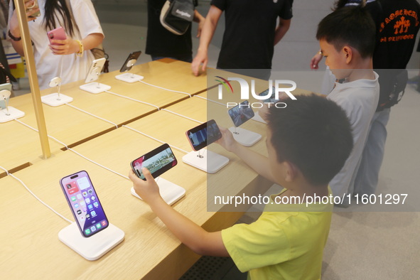 Customers experience Apple's new flagship mobile phone, the iPhone 16, at the largest Apple flagship store in Asia in Shanghai, China, on Se...