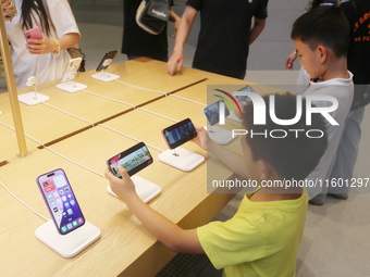 Customers experience Apple's new flagship mobile phone, the iPhone 16, at the largest Apple flagship store in Asia in Shanghai, China, on Se...