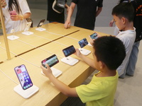 Customers experience Apple's new flagship mobile phone, the iPhone 16, at the largest Apple flagship store in Asia in Shanghai, China, on Se...