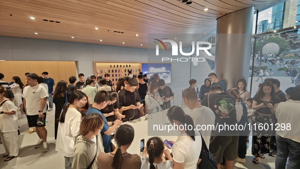 Customers experience Apple's new flagship mobile phone, the iPhone 16, at the largest Apple flagship store in Asia in Shanghai, China, on Se...