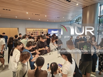 Customers experience Apple's new flagship mobile phone, the iPhone 16, at the largest Apple flagship store in Asia in Shanghai, China, on Se...