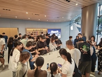 Customers experience Apple's new flagship mobile phone, the iPhone 16, at the largest Apple flagship store in Asia in Shanghai, China, on Se...