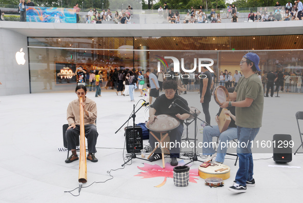 Customers experience Apple's new flagship mobile phone, the iPhone 16, at the largest Apple flagship store in Asia in Shanghai, China, on Se...