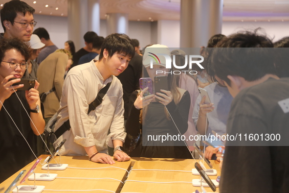 Customers experience Apple's new flagship mobile phone, the iPhone 16, at the largest Apple flagship store in Asia in Shanghai, China, on Se...