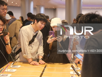 Customers experience Apple's new flagship mobile phone, the iPhone 16, at the largest Apple flagship store in Asia in Shanghai, China, on Se...