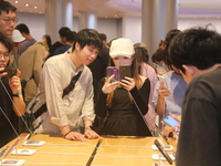 Customers experience Apple's new flagship mobile phone, the iPhone 16, at the largest Apple flagship store in Asia in Shanghai, China, on Se...