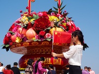 Tourists pose for a group photo in front of the flower beds at Tian 'anmen Square to celebrate the upcoming National Day in Beijing, China,...