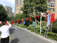 Workers hang national flags to welcome the upcoming National Day in Yancheng, China, on September 23, 2024. (