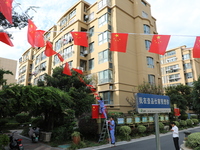 Workers hang national flags to welcome the upcoming National Day in Yancheng, China, on September 23, 2024. (