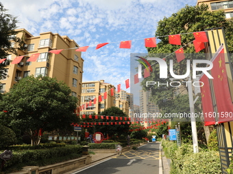 Workers hang national flags to welcome the upcoming National Day in Yancheng, China, on September 23, 2024. (