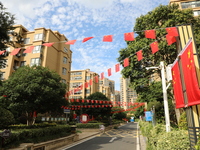 Workers hang national flags to welcome the upcoming National Day in Yancheng, China, on September 23, 2024. (