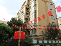 Workers hang national flags to welcome the upcoming National Day in Yancheng, China, on September 23, 2024. (