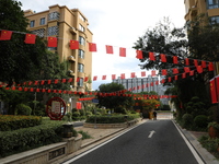 Workers hang national flags to welcome the upcoming National Day in Yancheng, China, on September 23, 2024. (