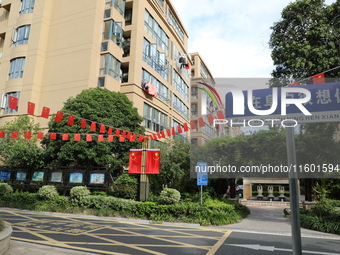 Workers hang national flags to welcome the upcoming National Day in Yancheng, China, on September 23, 2024. (