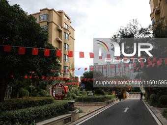 Workers hang national flags to welcome the upcoming National Day in Yancheng, China, on September 23, 2024. (