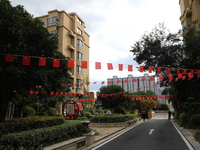 Workers hang national flags to welcome the upcoming National Day in Yancheng, China, on September 23, 2024. (