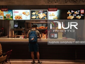 Customers purchase food at the Texas Chicken restaurant on Silom Road in Bangkok, Thailand, on September 23, 2024. Texas Chicken, the intern...