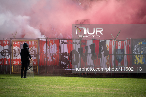 Resovia fans attend the game between Hutnik Krakow and Resovia Rzeszow in Krakow, Poland, on September 22, 2024. Team supporters burn smoke...