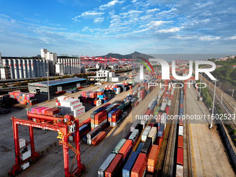 Large machinery loads containers onto a China-Europe freight train at the China-Kazakhstan (Lianyungang) logistics cooperation base in Liany...